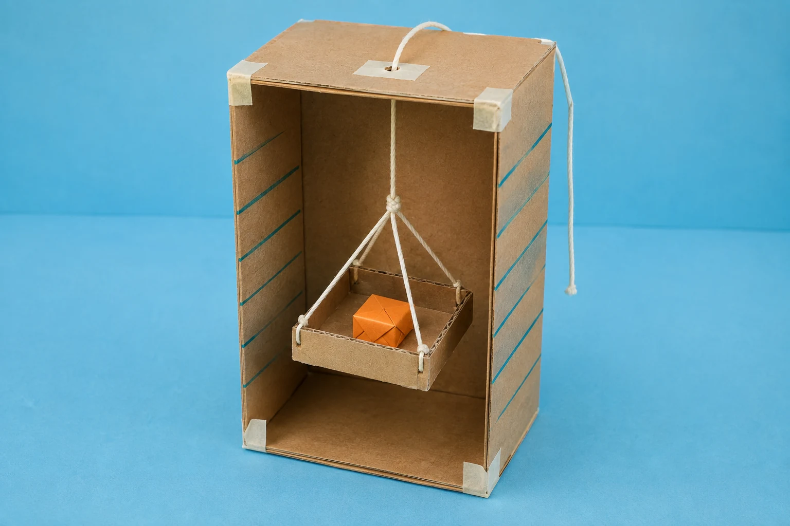 A small cardboard elevator with a suspended cargo tray.